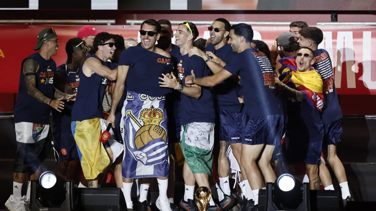 Oyarzabal luce la bandera de la Real durante la celebración del título en Madrid y Zubimendi la besa